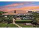 Aerial view of a home featuring a screened pool enclosure, lush landscaping, and a tile roof at 6461 Rubia Cir, Apollo Beach, FL 33572