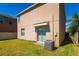 Home backyard featuring a sliding glass door, AC unit and view of the lawn and small outdoor patio at 6534 Trent Creek Dr, Ruskin, FL 33573