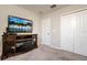 Bedroom with a TV above a wooden cabinet with an electric fireplace, and a double door closet at 6534 Trent Creek Dr, Ruskin, FL 33573