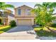 Two-story home boasts a tan exterior, two-car garage, and well-maintained landscaping at 6534 Trent Creek Dr, Ruskin, FL 33573