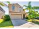Charming two-story home featuring a well-manicured lawn, mature landscaping, and a two-car garage at 6534 Trent Creek Dr, Ruskin, FL 33573