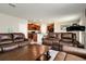 Open-concept living area featuring leather sofas, a coffee table, and seamless flow to the kitchen at 6534 Trent Creek Dr, Ruskin, FL 33573