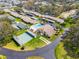 Aerial view of the community featuring a pool and shuffleboard court, surrounded by homes and green spaces at 6745 Basswood Cir, Zephyrhills, FL 33542