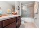 Bathroom featuring a tiled shower, single vanity, and neutral countertop at 6745 Basswood Cir, Zephyrhills, FL 33542