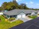 Low-angle view of well-maintained townhomes featuring landscaping, driveways, and attached garages at 6745 Basswood Cir, Zephyrhills, FL 33542