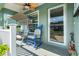 Charming front porch with ceiling fan, swing and rocking chair, perfect for relaxing outdoors at 6745 Basswood Cir, Zephyrhills, FL 33542