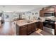 Open kitchen featuring wooden cabinets, modern appliances, and a view of the living area at 6745 Basswood Cir, Zephyrhills, FL 33542