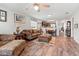 Open living room with hardwood floors and cozy seating with view of kitchen at 6745 Basswood Cir, Zephyrhills, FL 33542