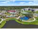 This aerial shot showcases community amenities including a pool, clubhouse, playground, sports courts, and a lake at 7413 Surrey Wood Ln, Apollo Beach, FL 33572