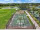 This aerial shot focuses on the community basketball court next to a lake and playground at 7413 Surrey Wood Ln, Apollo Beach, FL 33572