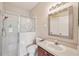 Neutral bathroom with glass shower, decorative etching, white toilet, vanity with ample space and a brushed metal mirror at 7413 Surrey Wood Ln, Apollo Beach, FL 33572
