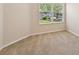 An empty carpeted room with a window and a neutral color scheme at 7413 Surrey Wood Ln, Apollo Beach, FL 33572