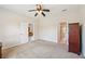Spacious bedroom featuring ceiling fan, neutral carpet, and ensuite bathroom at 7413 Surrey Wood Ln, Apollo Beach, FL 33572