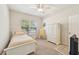 This bright bedroom showcases a single bed, white furniture and a ceiling fan at 7413 Surrey Wood Ln, Apollo Beach, FL 33572
