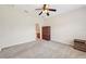 Bedroom with neutral carpet, ceiling fan, and an ensuite bathroom entrance at 7413 Surrey Wood Ln, Apollo Beach, FL 33572