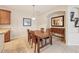 Cozy dining area featuring a wooden table with chairs, neutral walls, tile floors, and a decorative mirror at 7413 Surrey Wood Ln, Apollo Beach, FL 33572