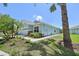 Charming single-story home featuring stone accents, lush landscaping, and a well-manicured lawn on a sunny day at 7413 Surrey Wood Ln, Apollo Beach, FL 33572