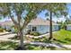 Well-kept single-story home featuring stone accents, beautiful landscaping, and a lush green lawn on a sunny day at 7413 Surrey Wood Ln, Apollo Beach, FL 33572