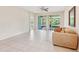 Spacious living room with tile flooring, neutral walls, ceiling fan, and sliding doors that lead to the lanai at 7413 Surrey Wood Ln, Apollo Beach, FL 33572