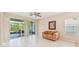 Bright living room featuring tile flooring, neutral walls, a ceiling fan, and sliding glass doors to the lanai at 7413 Surrey Wood Ln, Apollo Beach, FL 33572