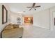 Open concept living room with tile flooring, neutral walls, a ceiling fan, and a view into the kitchen at 7413 Surrey Wood Ln, Apollo Beach, FL 33572