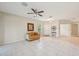 Light and airy living room with tile flooring, neutral walls, a ceiling fan, and a view of the front entrance at 7413 Surrey Wood Ln, Apollo Beach, FL 33572