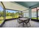 A screened patio with a dining table and chairs overlooks a lush green yard at 7413 Surrey Wood Ln, Apollo Beach, FL 33572
