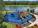 A high angle view of a vibrant community playground with slides and climbing frames near a lake at 7413 Surrey Wood Ln, Apollo Beach, FL 33572