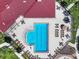 Aerial view of a pristine pool with lounge chairs and tables, perfect for community recreation and relaxation at 7413 Surrey Wood Ln, Apollo Beach, FL 33572