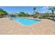 Inviting community pool with brick paver deck and tropical landscaping at 7413 Surrey Wood Ln, Apollo Beach, FL 33572