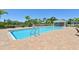 Community pool featuring brick paver deck, tropical landscaping, and nearby cabana at 7413 Surrey Wood Ln, Apollo Beach, FL 33572