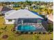 Aerial view of a private pool and outdoor living space, surrounded by lush landscaping and a well-manicured lawn at 7504 Carissa, Punta Gorda, FL 33955