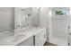 Bright bathroom featuring double sinks, white cabinets, and a walk-in shower with marble tile at 7504 Carissa, Punta Gorda, FL 33955