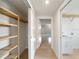 Hallway leading to laundry room and a storage area, featuring light tile floors at 7504 Carissa, Punta Gorda, FL 33955