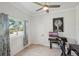 Bright office space with light wood floors, a modern desk setup, and a large window at 7504 Carissa, Punta Gorda, FL 33955