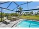 Private pool area with a lounge chair, dining table, and lush landscaping surrounding the pool at 7504 Carissa, Punta Gorda, FL 33955