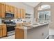 Open kitchen featuring wood cabinets, granite countertops, and stainless steel appliances, perfect for cooking at 7725 Bingham Ct, Tampa, FL 33625