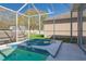 Relaxing pool with a screened enclosure and tiled hot tub, perfect for backyard enjoyment at 7725 Bingham Ct, Tampa, FL 33625