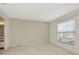 This carpeted bedroom has a window for natural light and an adjacent bathroom at 8013 Savannah Sunset Ln, Tampa, FL 33615