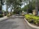 Gated entrance to a deed-restricted community with lush landscaping and mature trees at 8013 Savannah Sunset Ln, Tampa, FL 33615