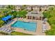 Community pool with blue sun shade over lounge chairs, and a clubhouse facility with tables and chairs at 8013 Savannah Sunset Ln, Tampa, FL 33615