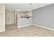 Open concept living room and kitchen with tile flooring and neutral wall color at 8013 Savannah Sunset Ln, Tampa, FL 33615