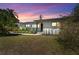 Charming home with a well-manicured lawn and beautiful landscaping at sunset at 807 W Braddock St, Tampa, FL 33603