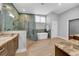 Modern bathroom featuring tile walls and flooring, glass shower, soaking tub, and dual marble countertop sinks at 915 Bayshore Dr, Tarpon Springs, FL 34689