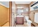 Traditional-style bathroom with patterned wallpaper, tile shower, vanity, and decorative mirror at 915 Bayshore Dr, Tarpon Springs, FL 34689
