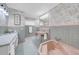Vintage bathroom with pink fixtures, floral wallpaper, and tiled walls, creating a retro and charming aesthetic at 915 Bayshore Dr, Tarpon Springs, FL 34689
