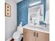 Stylish powder room featuring a blue tiled wall, modern vanity and hardware, and hardwood floors at 915 Bayshore Dr, Tarpon Springs, FL 34689