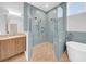 Modern bathroom featuring tile walls, glass shower, soaking tub, wood floors, and marble countertop sink at 915 Bayshore Dr, Tarpon Springs, FL 34689