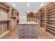 A walk-in closet featuring custom shelving, drawers, and a center island with a marble countertop for storage solutions at 915 Bayshore Dr, Tarpon Springs, FL 34689