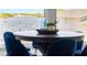 Close up of a round dining table with blue velvet chairs showcasing a view of the waterway at 915 Bayshore Dr, Tarpon Springs, FL 34689